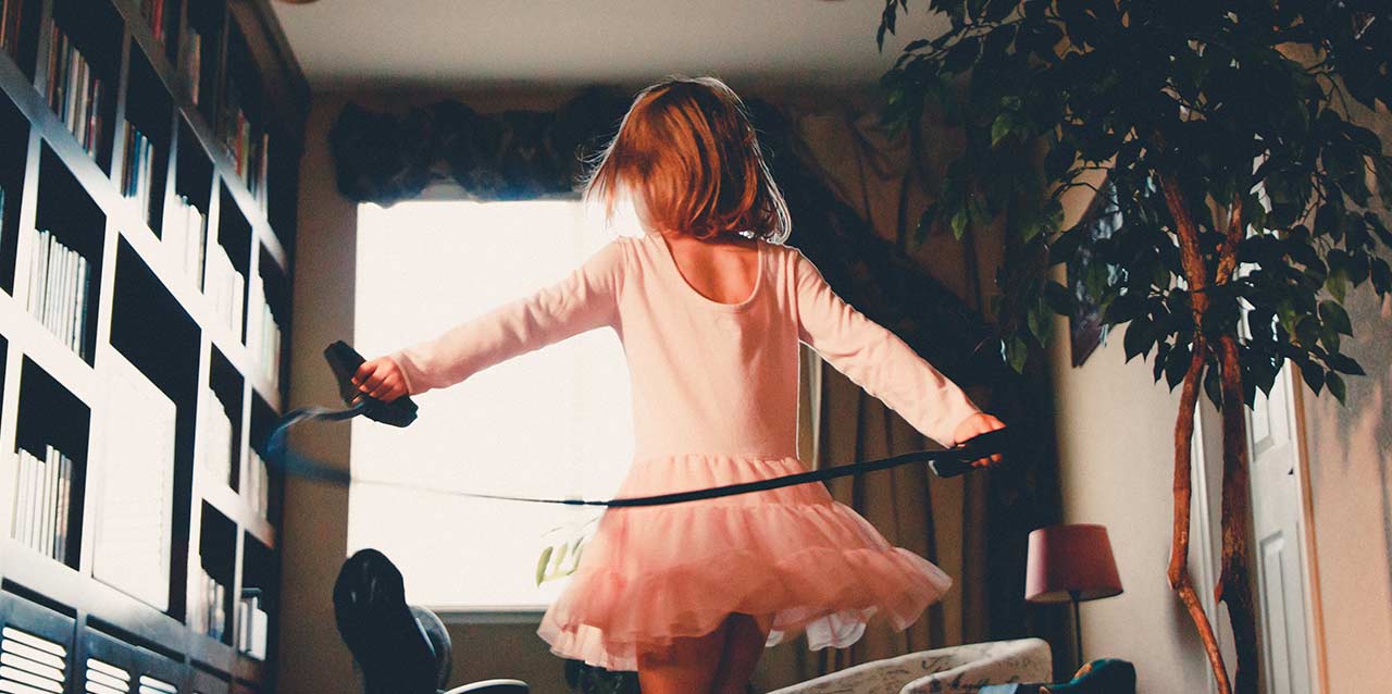 niña con vestido saltando a la comba