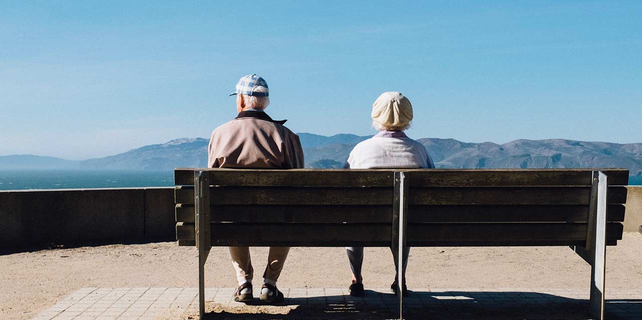 pareja anciana sentada en banco de madera