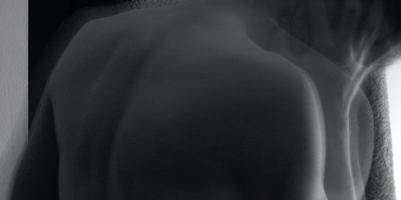 como-evitar-el-dolor-de-espalda-al-levantarse-de-la-cama hombre borroso en blanco y negro
