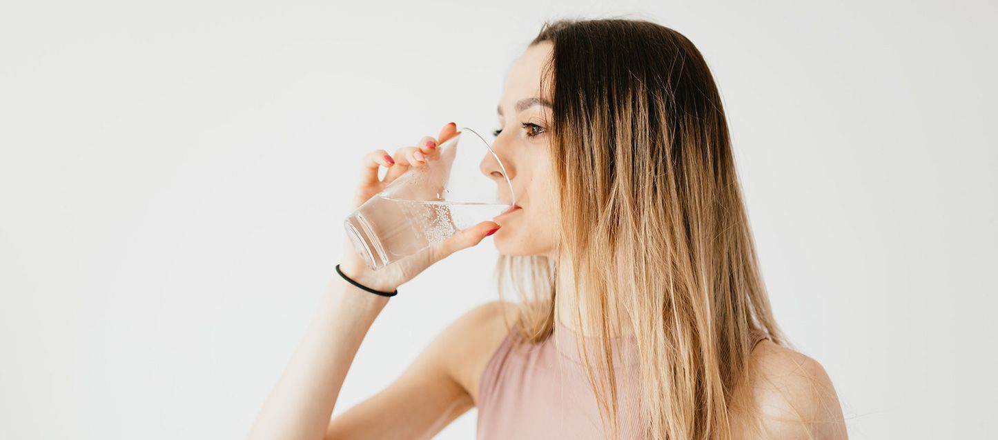 beber agua antes de irse a dormir Una chica bebiendo un vaso de agua